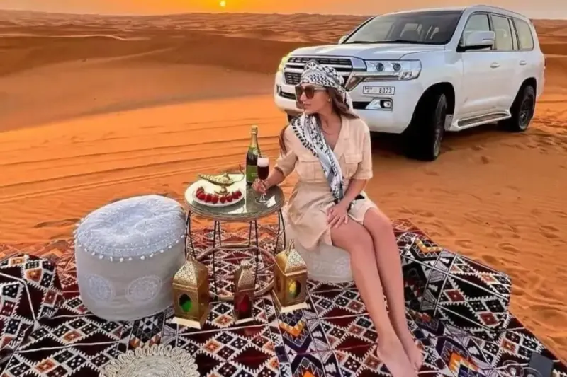 Private VIP desert setup with lanterns and a Land Cruiser at sunset in Dubai