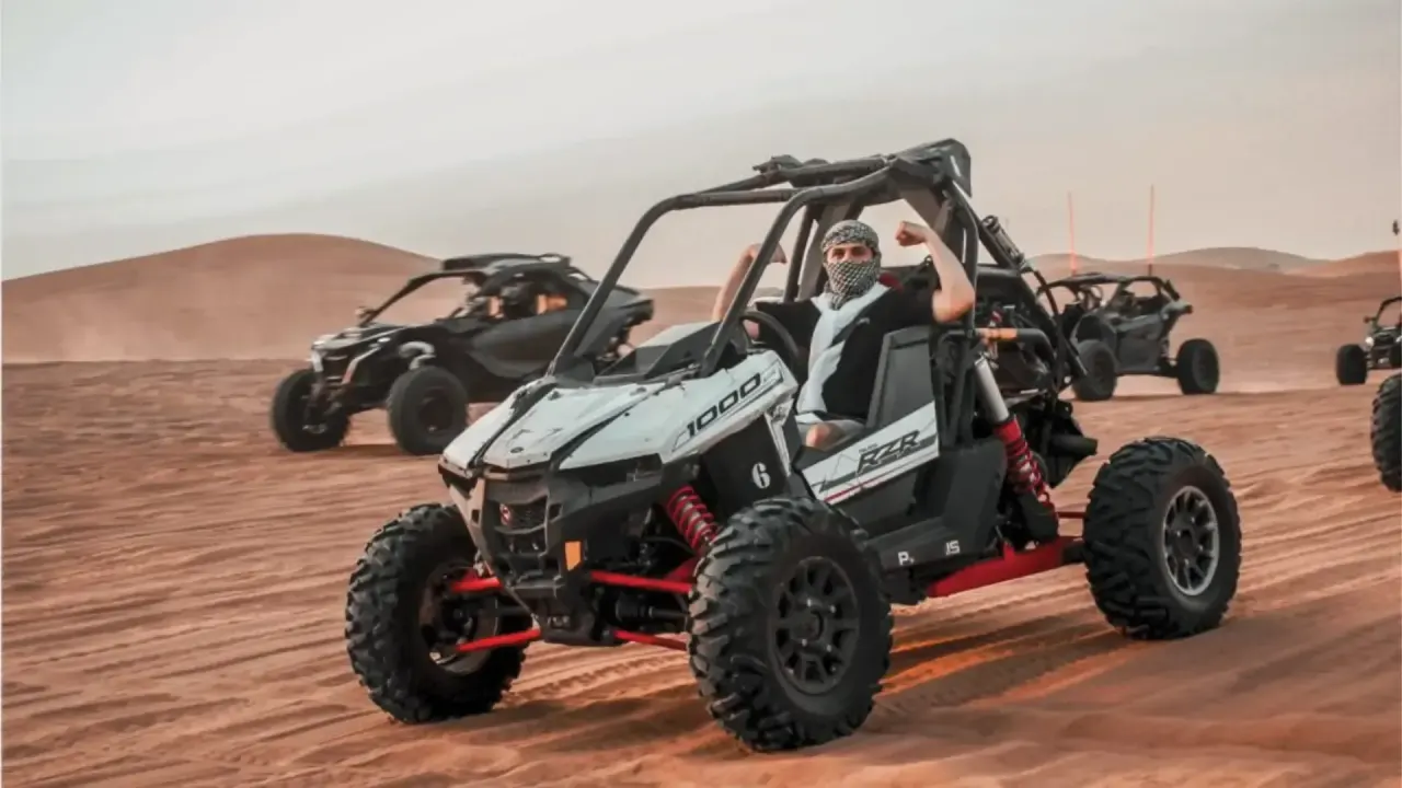 Polaris RZR 1000cc dune buggy leading a convoy of buggies in the Dubai desert
